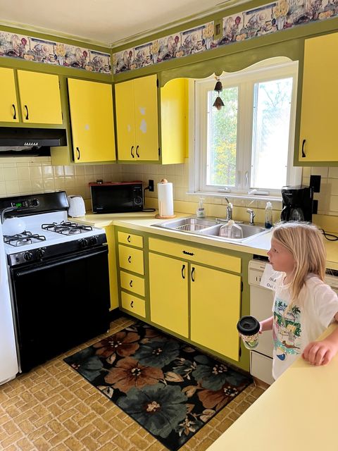 A bright kitchen with yellow cabinets.